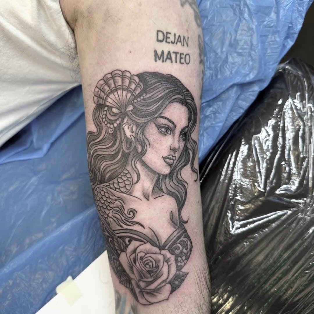 Kvinnoporträtt med solfjäder och rosor i black & grey på arm av Kain Toro, Zoi Tattoo House Malmö