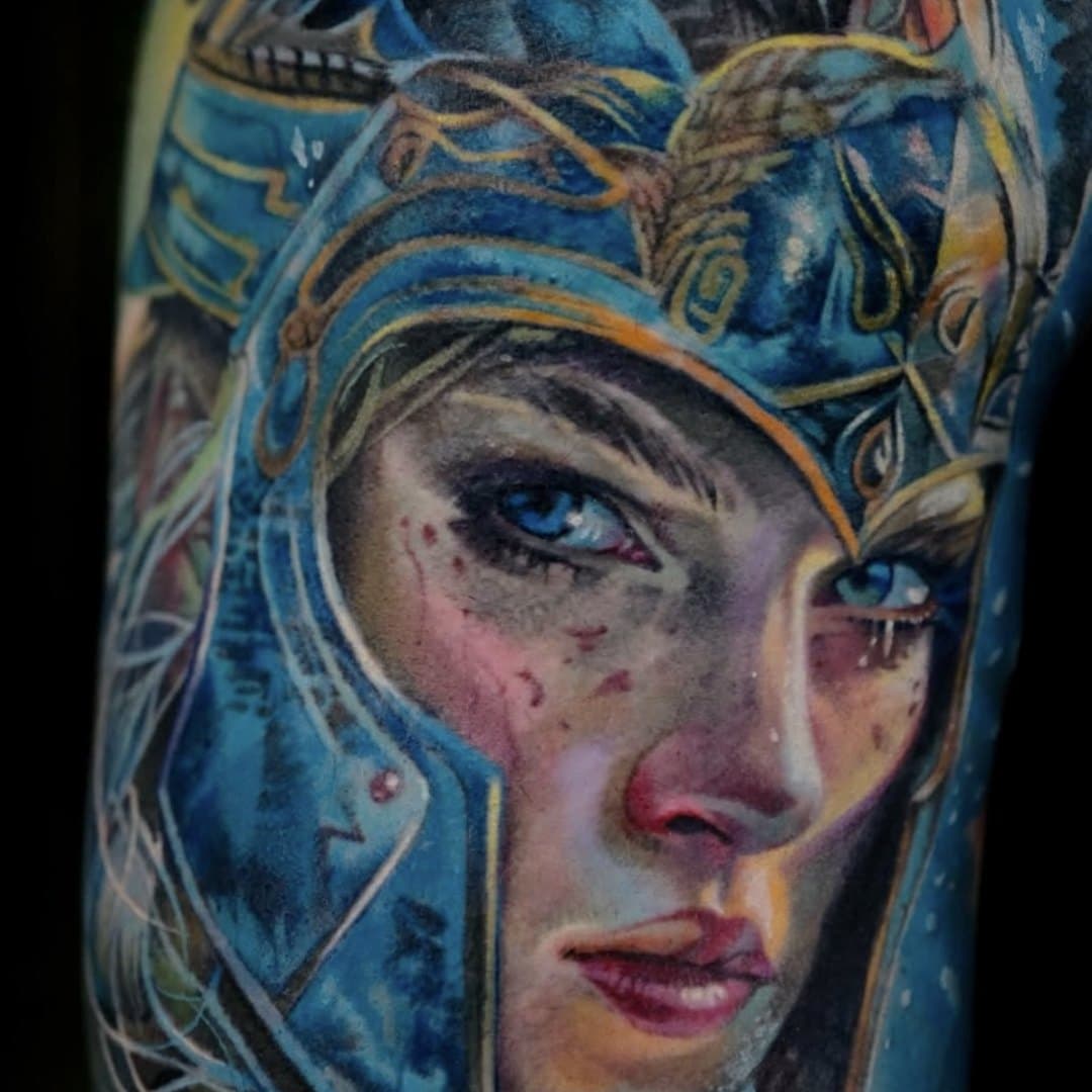 Realistiskt kvinnoporträtt i färg med hjälm och blå toner av Tymur Denysenko, Zoi Tattoo House Malmö