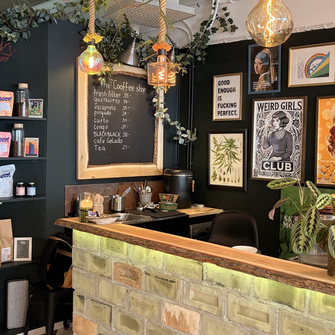 Baren i The Coffee Shop hos Zoi Tattoo House i Malmö, med kaffemenyn skriven på en krittavla