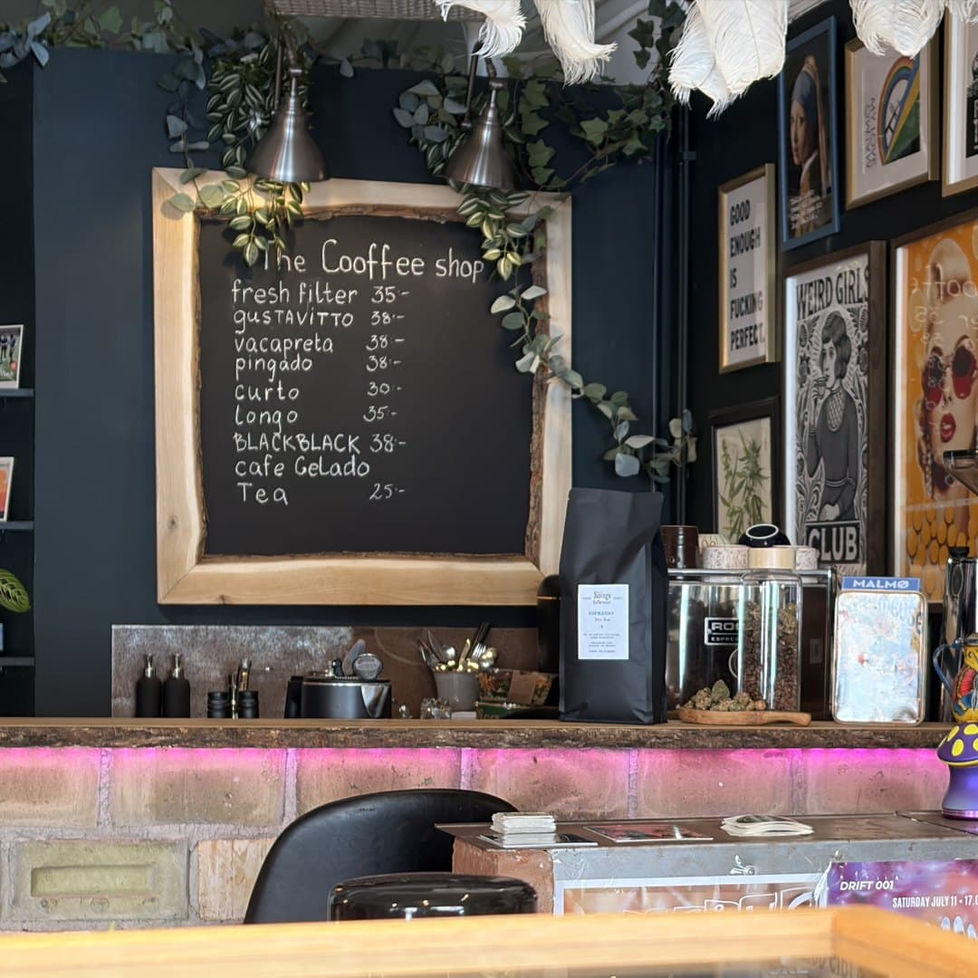 Kaffemenyn skriven på en krittavla bakom baren i The Coffee Shop hos Zoi Tattoo House i Malmö